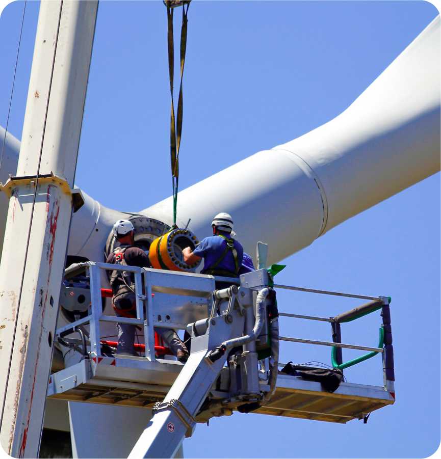 Man in crane fixing wind turbine